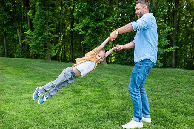 Dad swinging boy