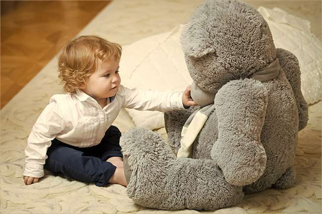 toddler with large stuffed bear